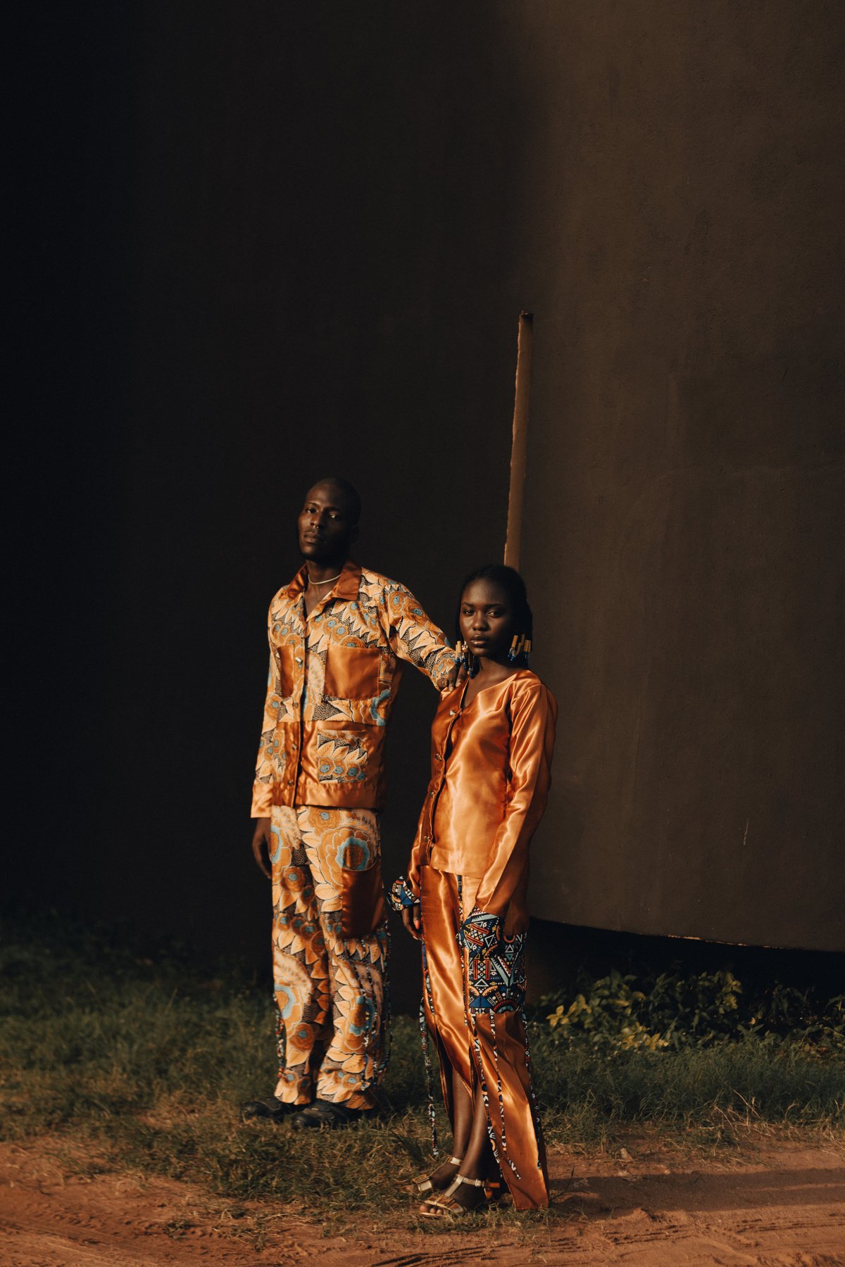 Man and Woman in Orange Printed Outfits Outdoors