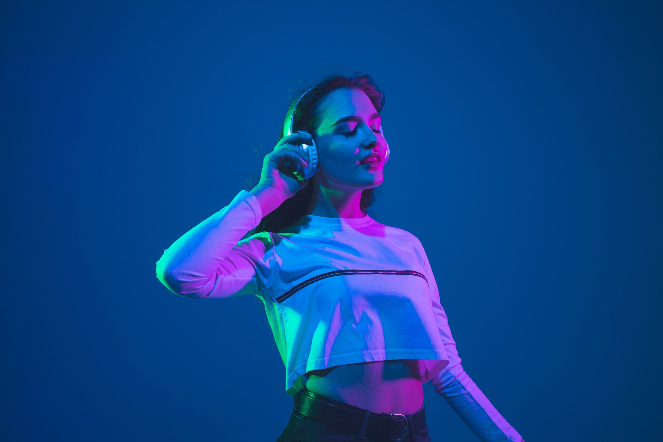 Woman Listening to Music Isolated on Neon Studio Background